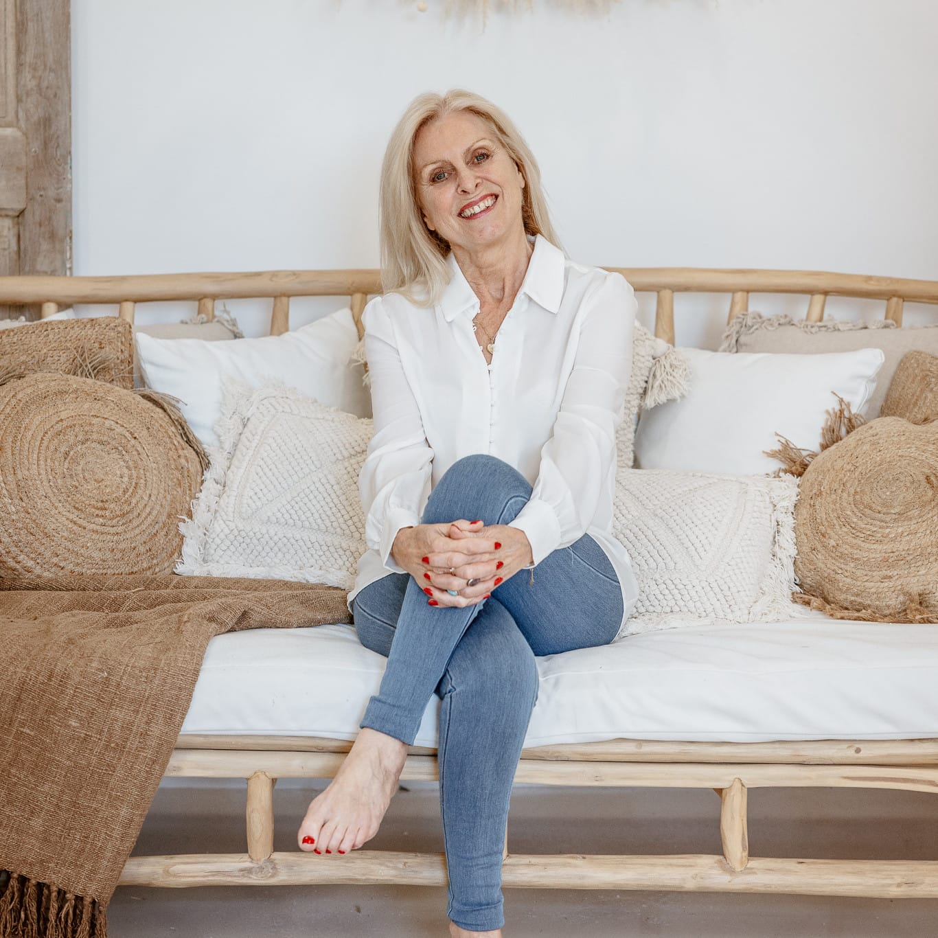 On a cozy wicker couch, Val Hood, an Evidential Medium, enjoys her space.